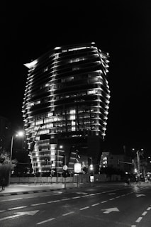 Completed modern building illuminated by solar-powered street lighting at night.