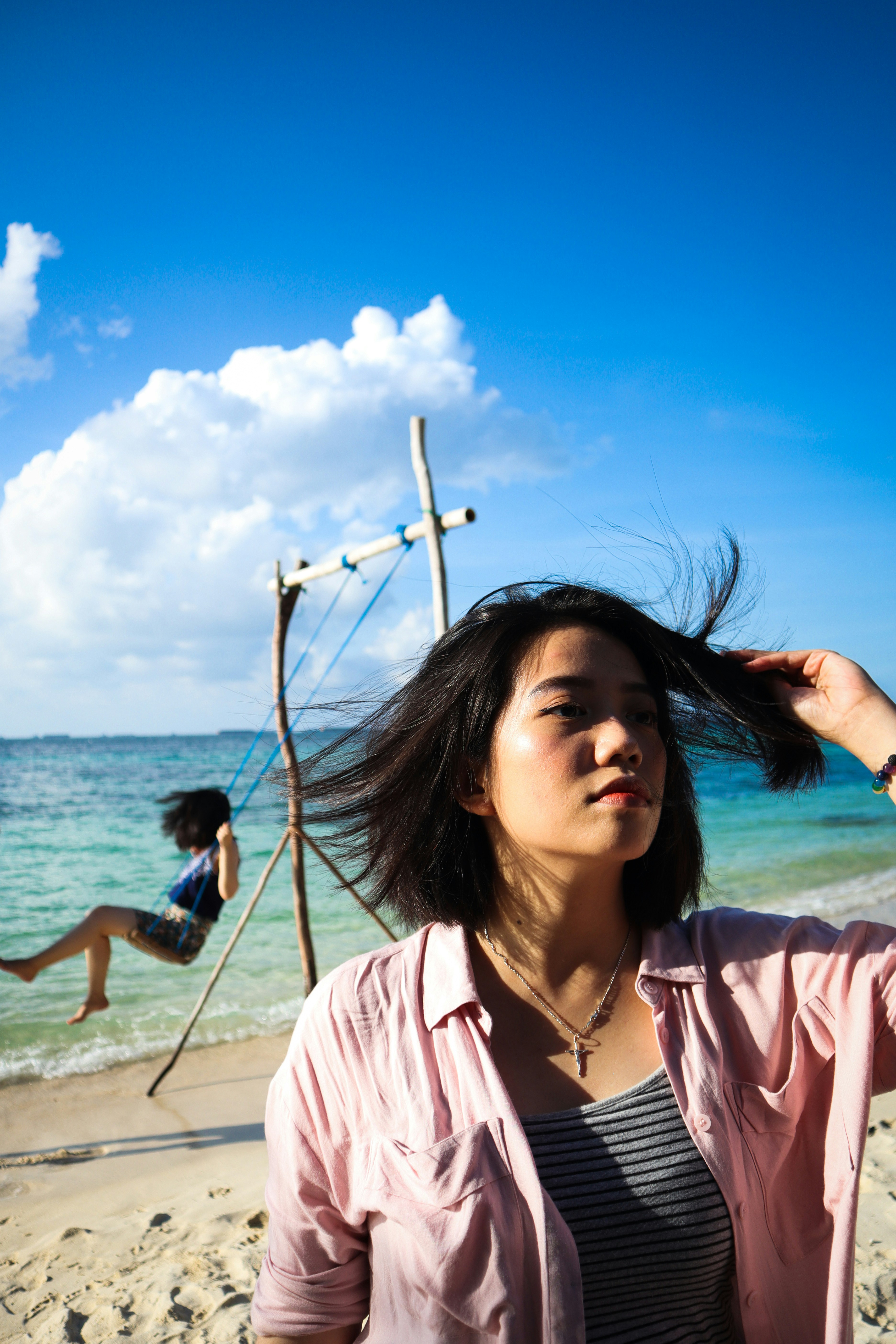 great photo recipe,how to photograph a breezy noon; woman wearing pink jacket standing on seashore