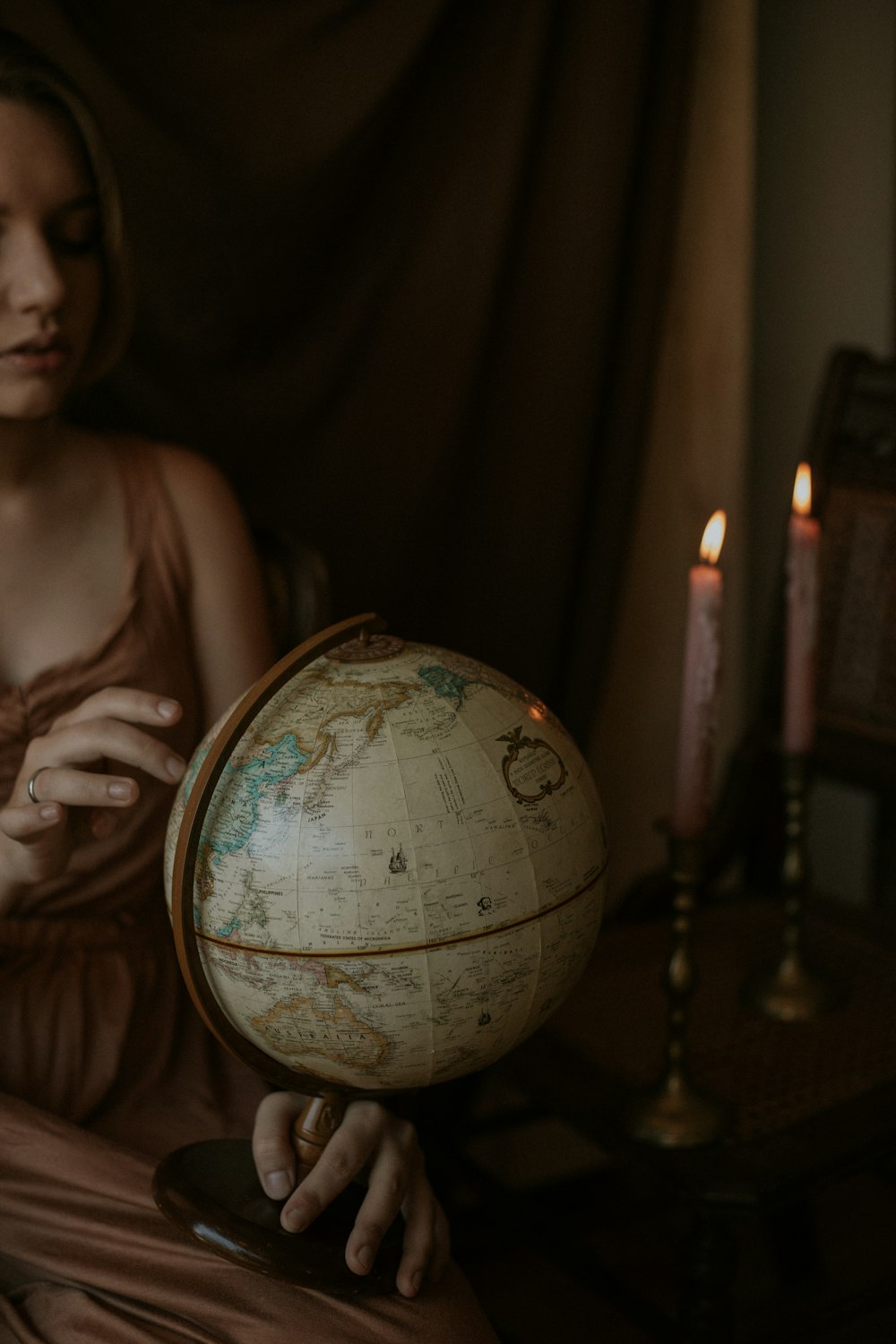 woman wearing brown dress holding white globe