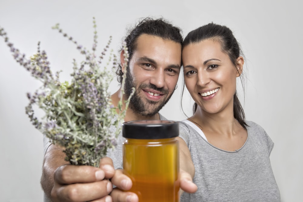 man and woman holding plants