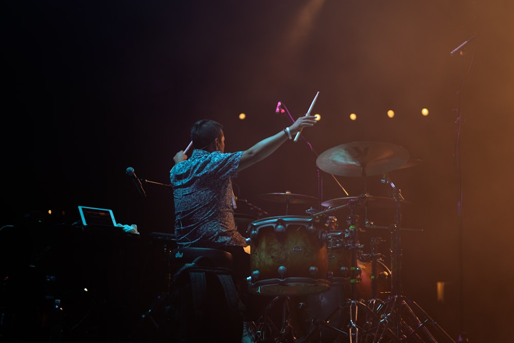 a man is playing drums on stage at a concert
