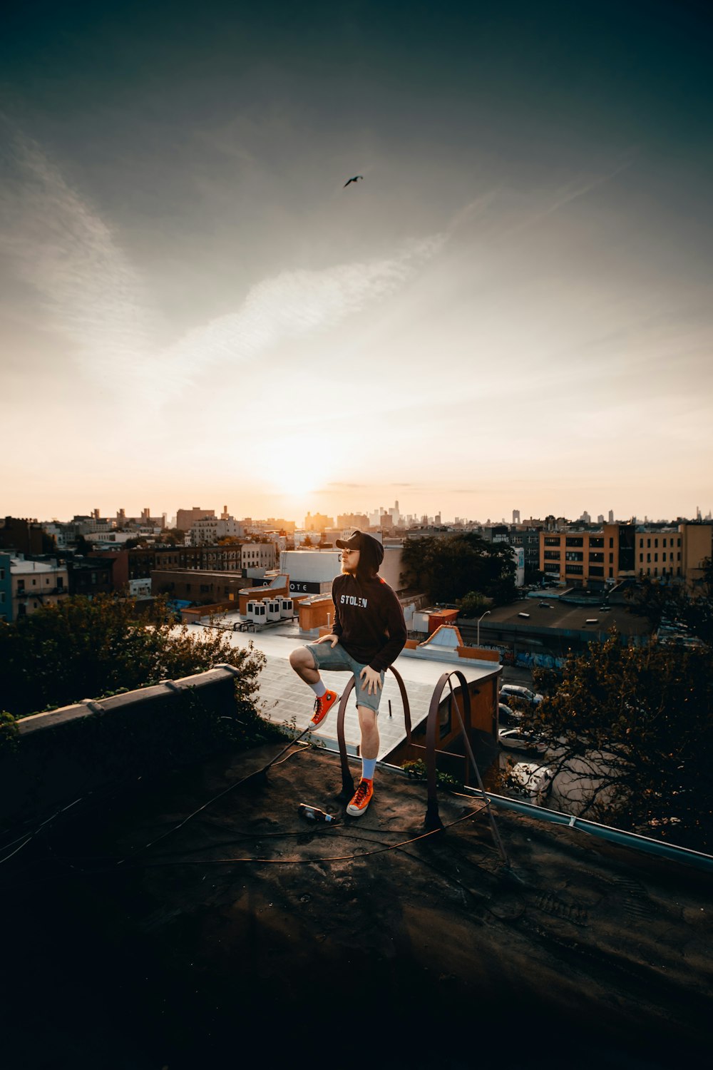 person wearing black hoodie sitting on metal ladder