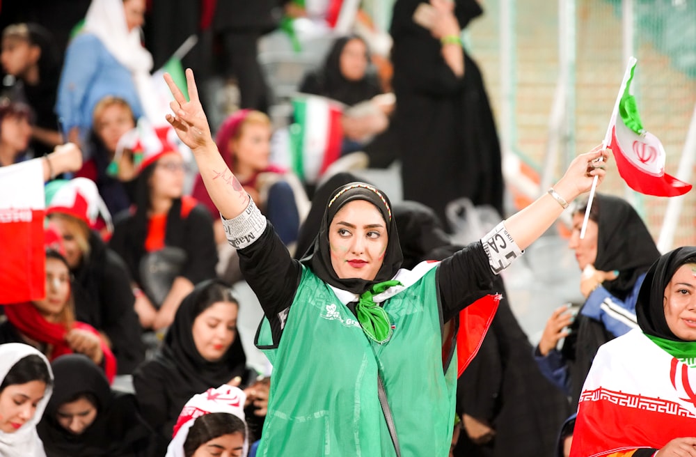 standing woman wearing gray and black jacket while raising her hands