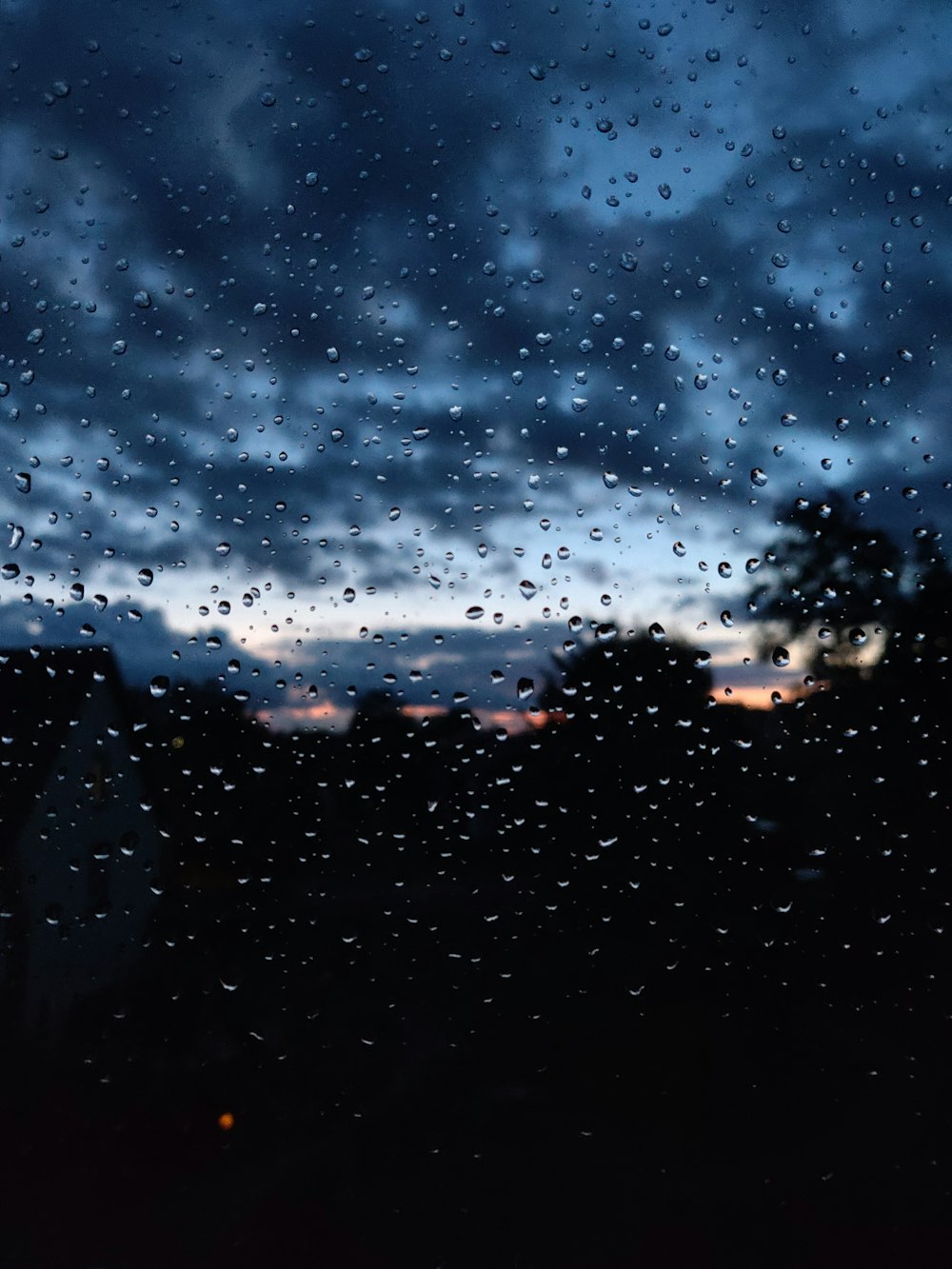 rain drops on a window as the sun sets