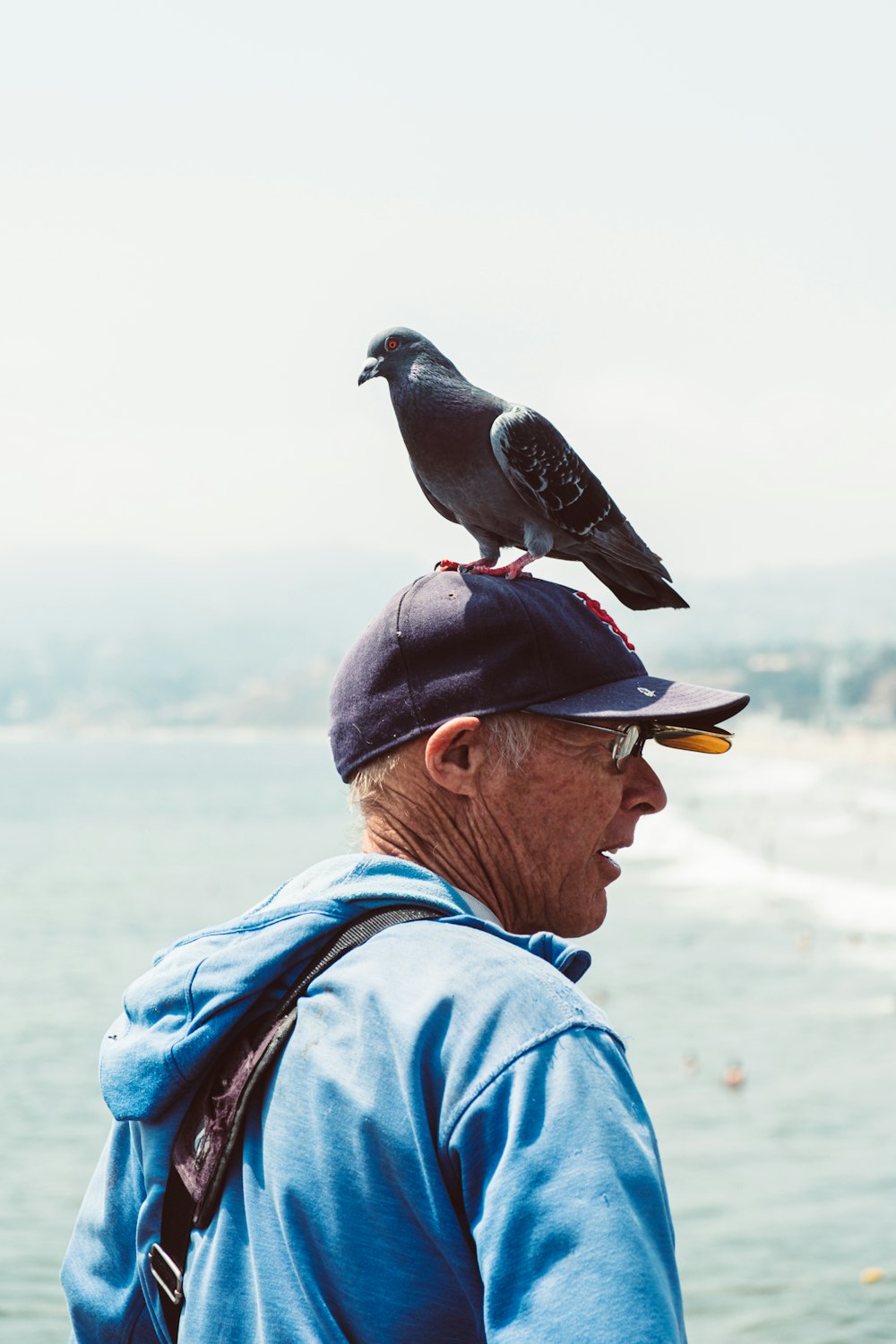 Un uomo con un uccello sulle spalle