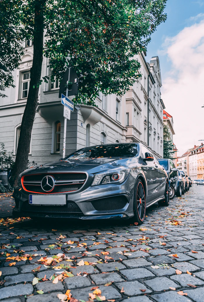 Gray sedan parked on a cobblestone street