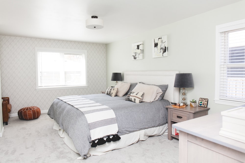 bed with comforter beside nightstand with table lamp