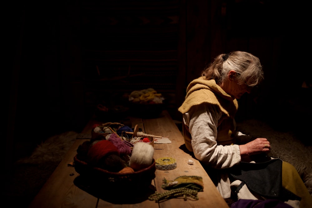 Mujer con suéter gris al lado de la mesa