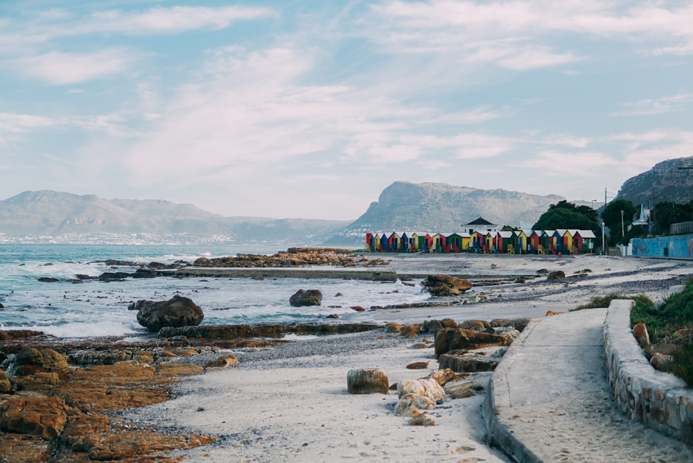 multicolored beach houses viewing mountain under white and blue sky during daytime