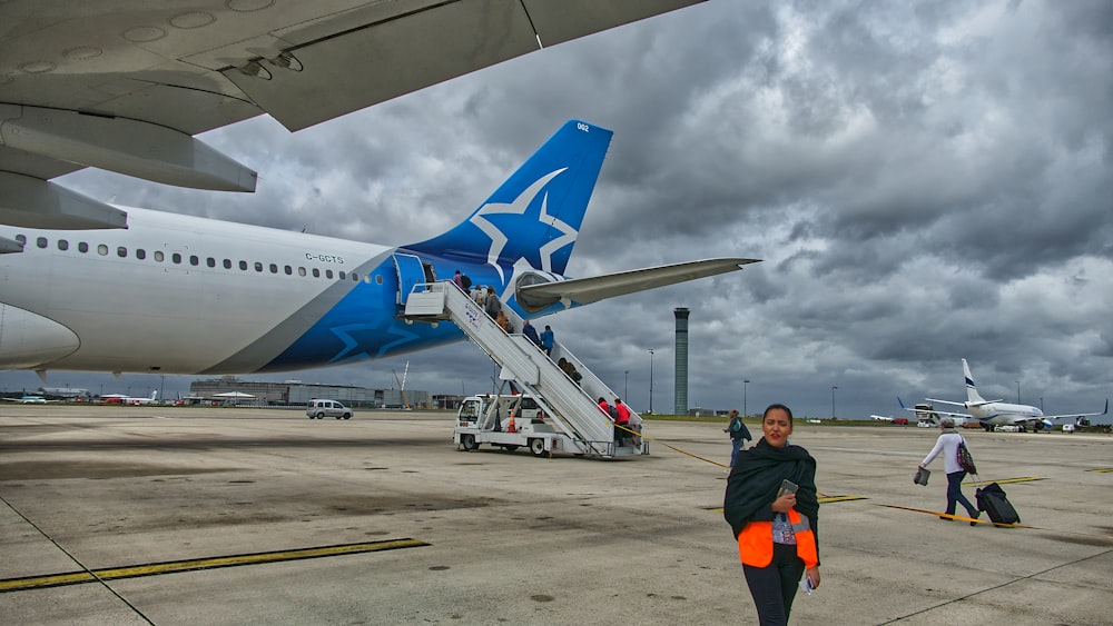 woman walking inside airport near airplane