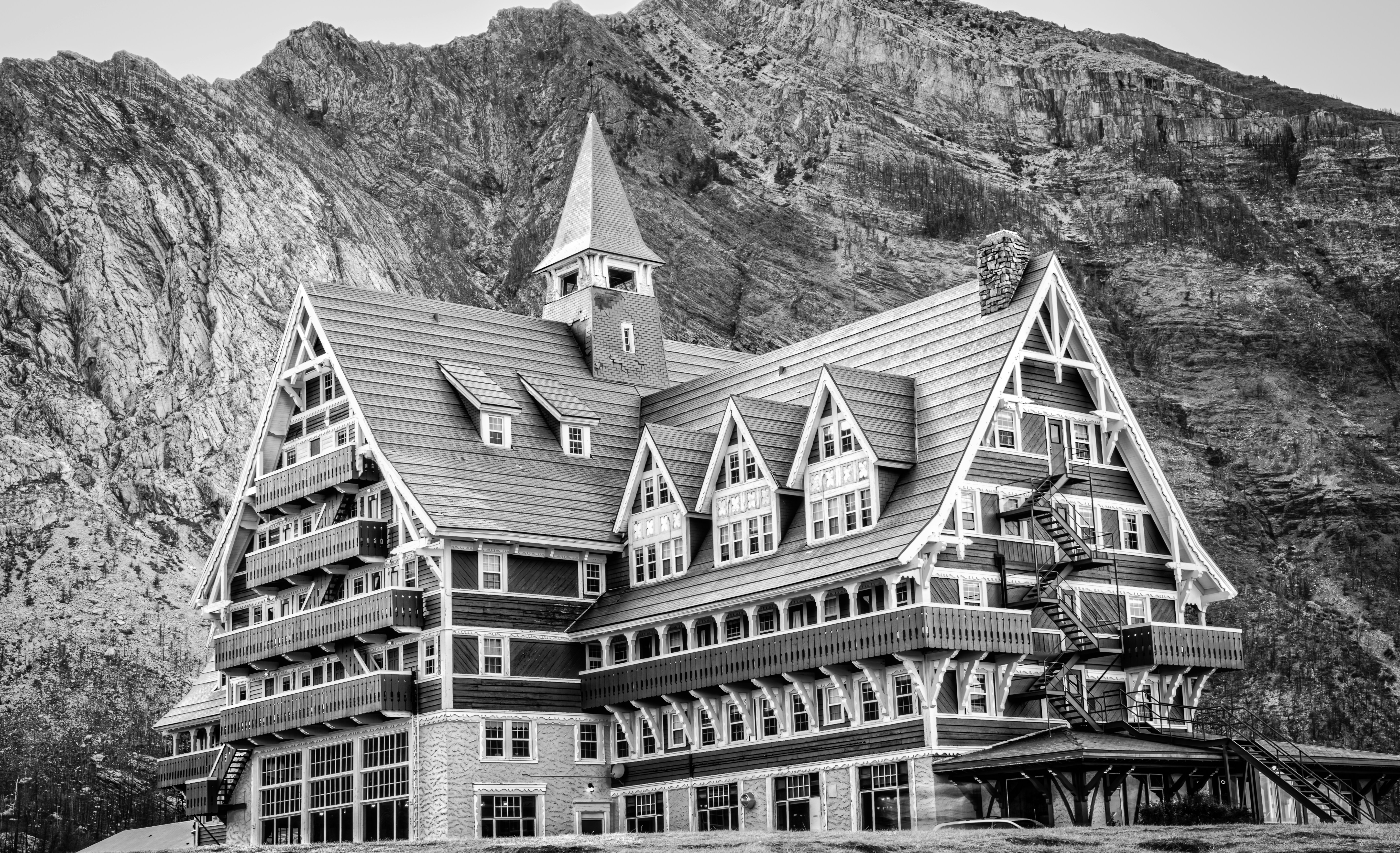 grayscale photography of house beside mountain