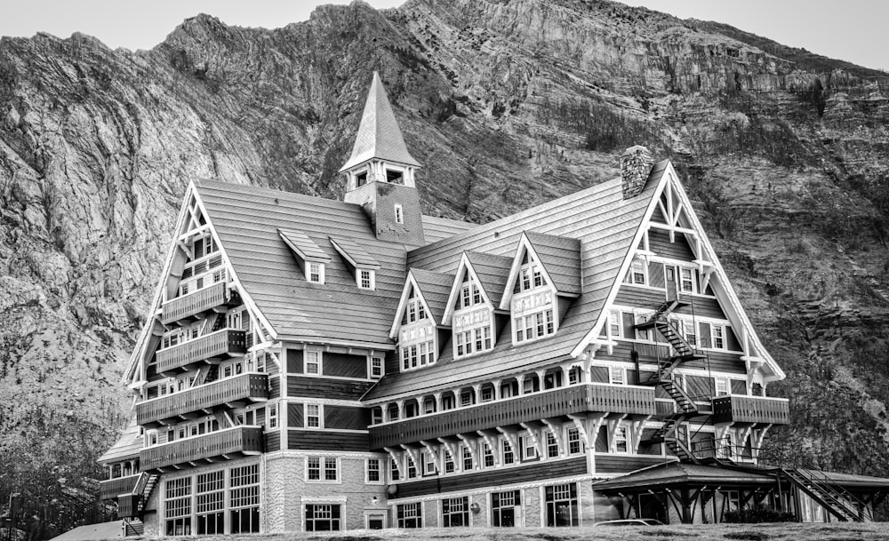 grayscale photography of house beside mountain