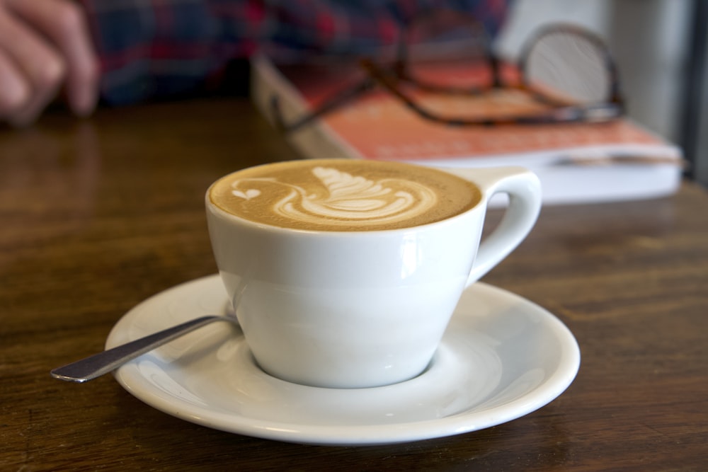 white ceramic teacup with latte