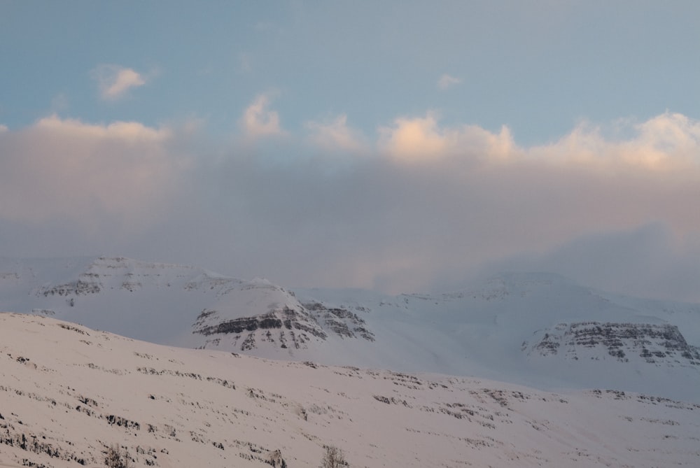 montanha coberta de neve sob o céu branco e azul durante o dia