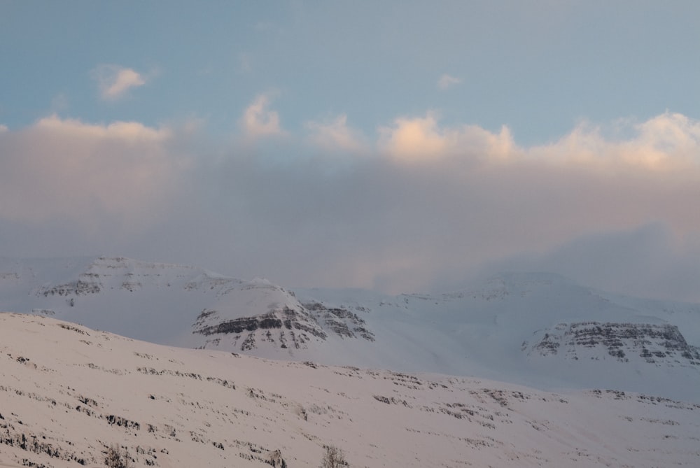 mountain covered with snow under white and blue sky during daytime