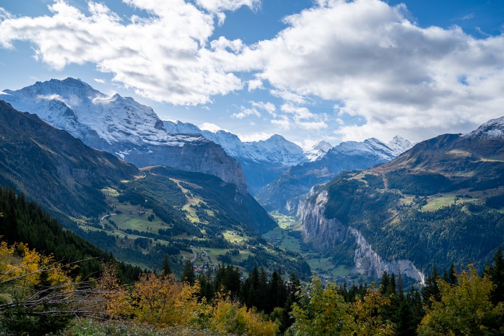 mountains under white clouds and blue sky