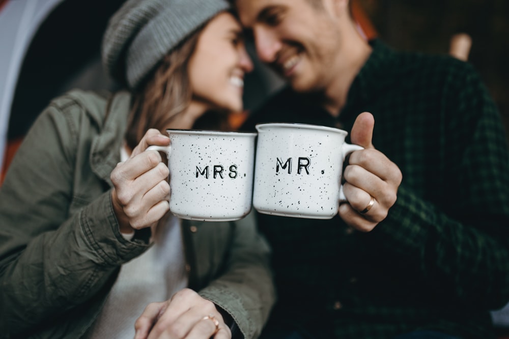 smiling man and woman holding Mrs. and Mr. mugs