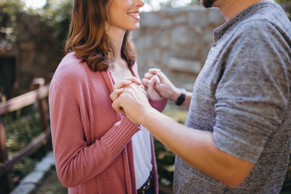 man and woman holding hands standing on garden