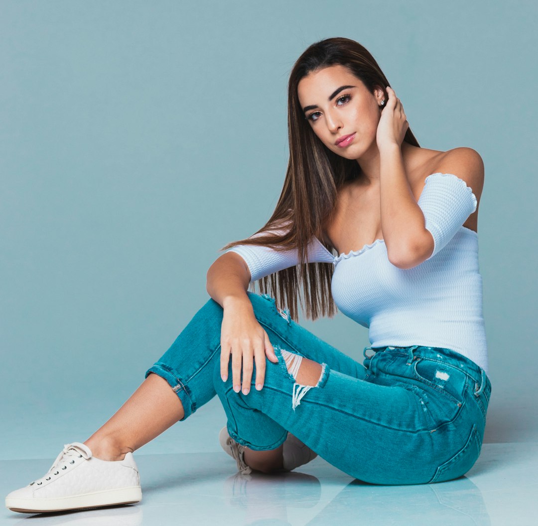 woman wearing white off-shoulder blouse and blue jeans