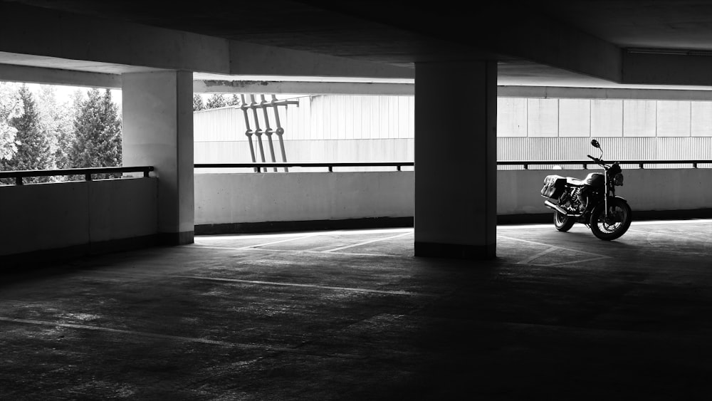 grayscale photo of motorcycle parked inside building