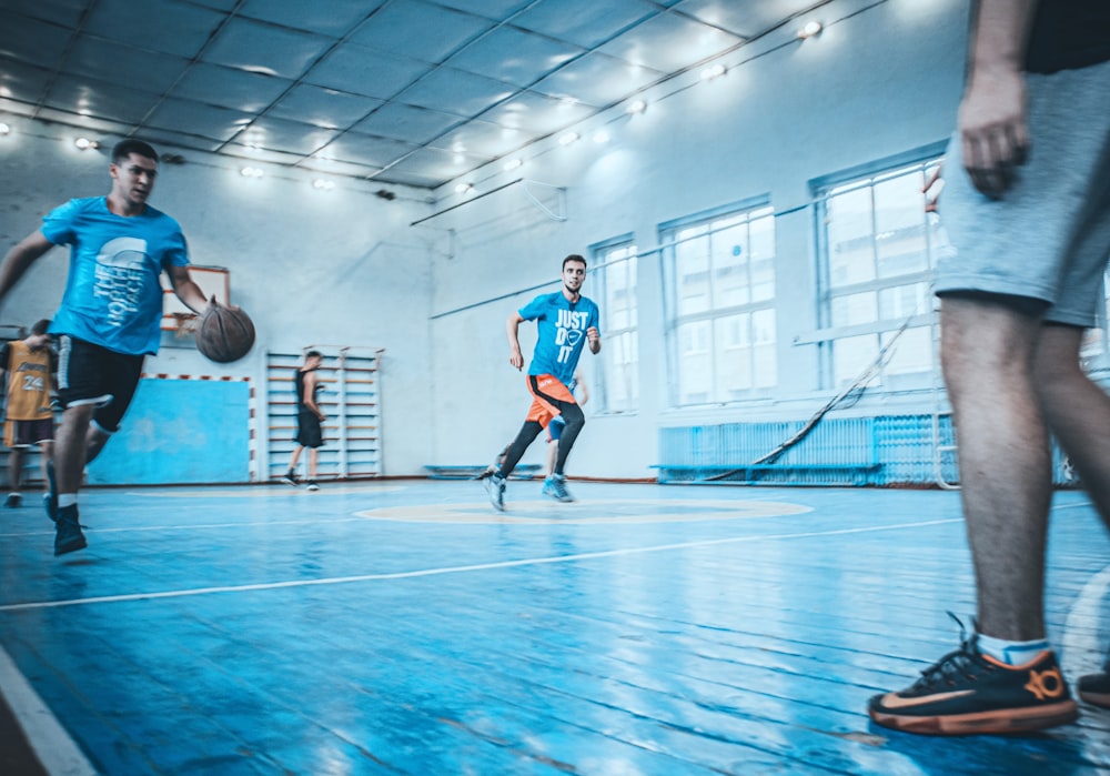 man in blue t-shirt dribbling basketball