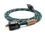 A coiled green woven power cable with white accents features a wooden label that reads 'Arapuni PH-1, Designed in New Zealand.' The plug is black with visible metal prongs and labeled 'Furutech.'
