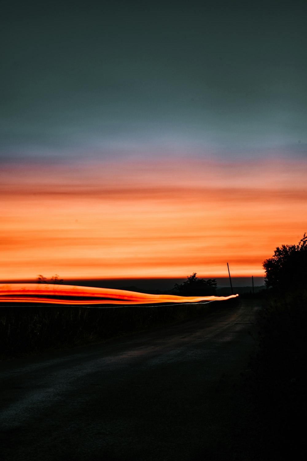 Una strada con un tramonto sullo sfondo