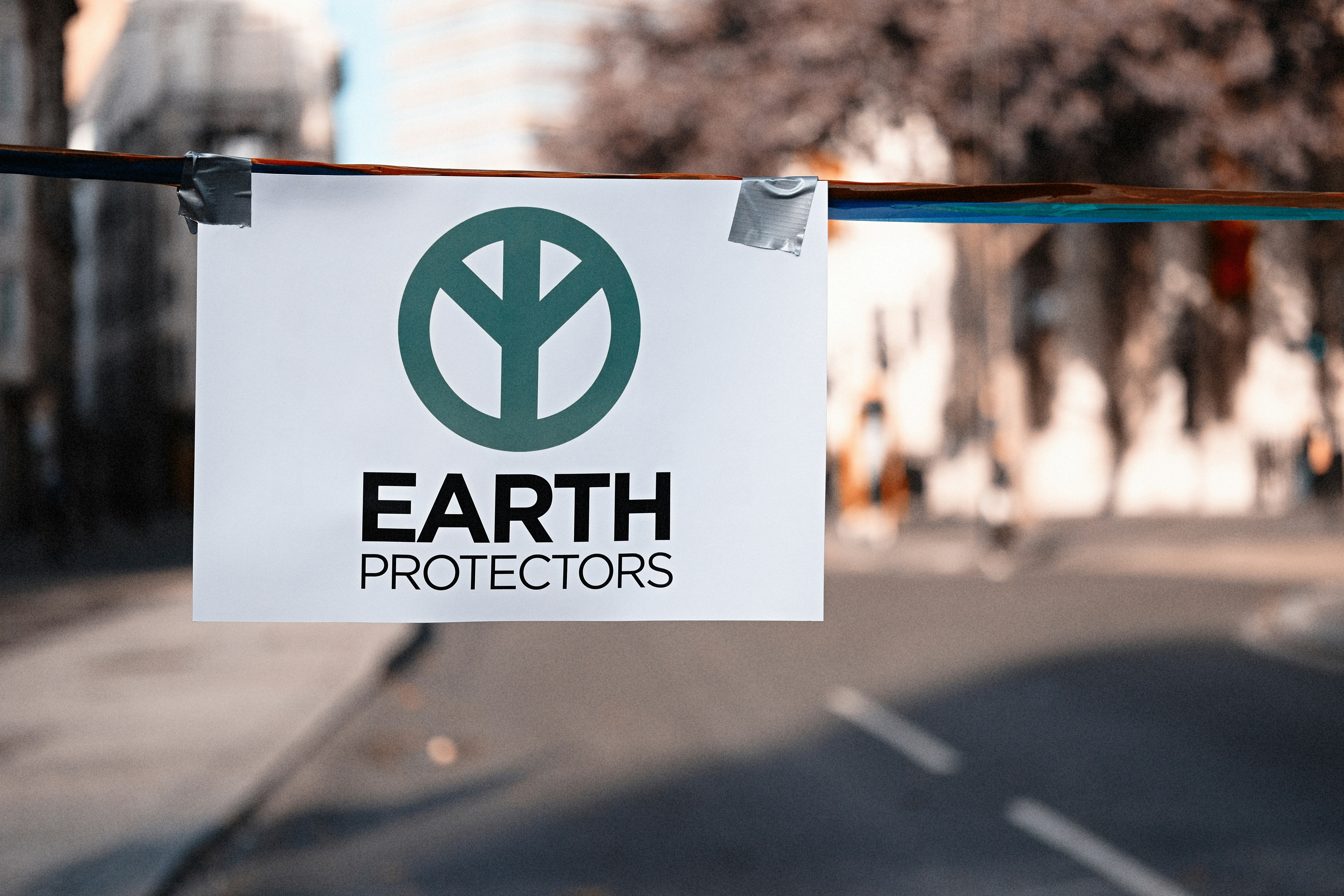 a sign hanging from a wire on a city street