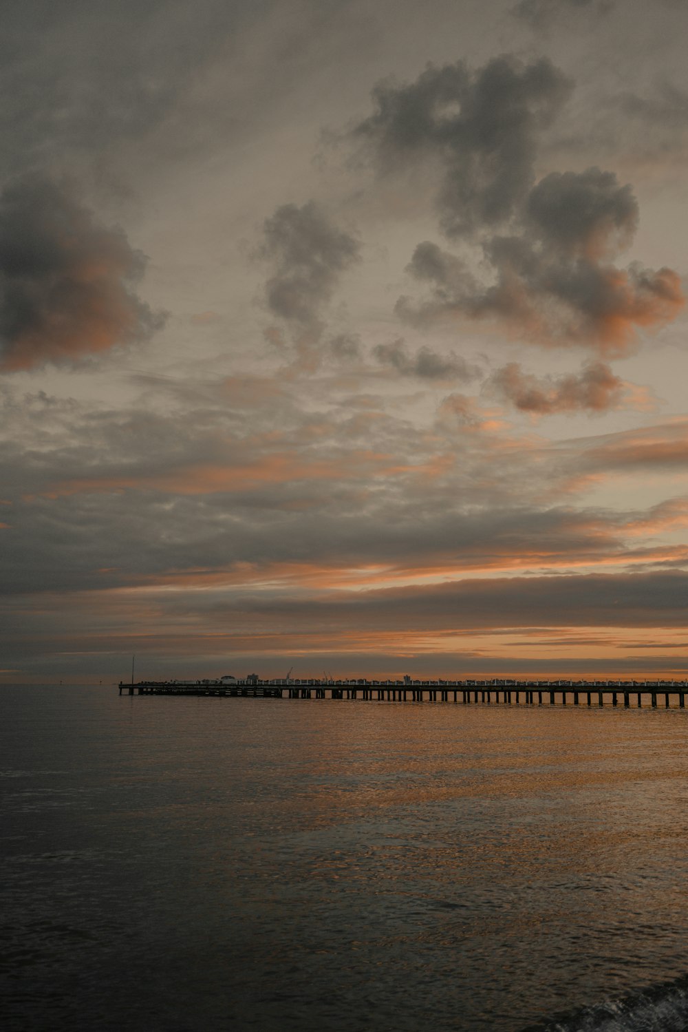 Muelle negro junto a la masa de agua en la hora dorada