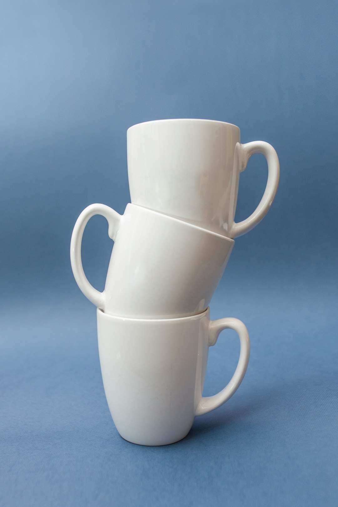  three stacked white ceramic cups cup