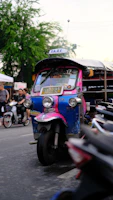 A colorful tuktuk parked near Madrid's historic Plaza Mayor with vibrant city life around