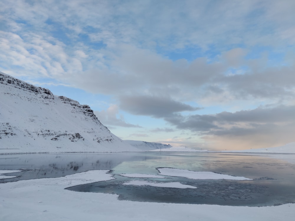 glacier mountain and snow covered shore during day