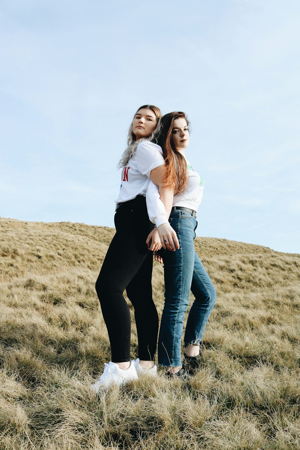 femme debout dos à dos sur le champ d’herbe pendant la journée