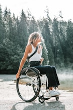 woman riding wheelchair near trees