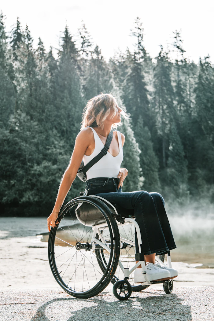 A woman using a wheelchair on a tree-lined path
