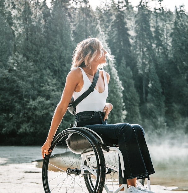 woman riding wheelchair near trees