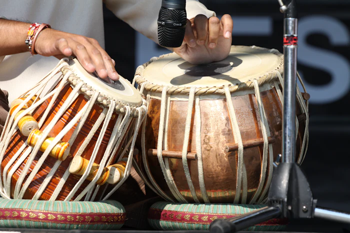 Hands playing a pair of Indian percussion drums on stage