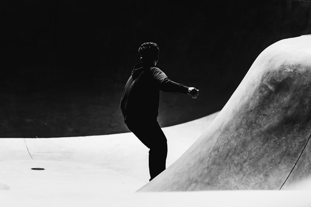 Photo en niveaux de gris d’un homme patinant