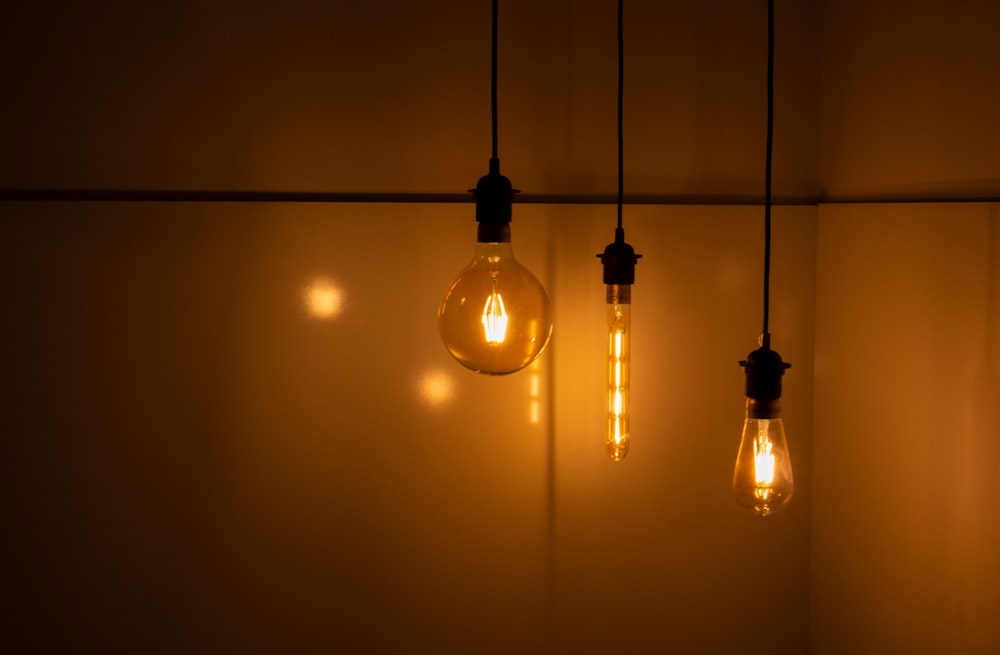 three clear light bulbs near wall