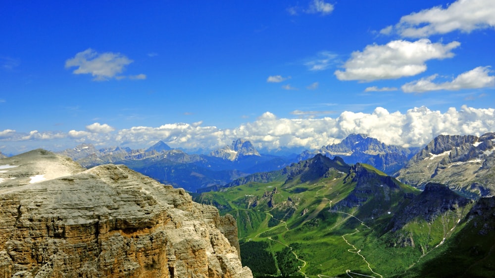 aerial view of rocky mountain and green mountains during cloudy day