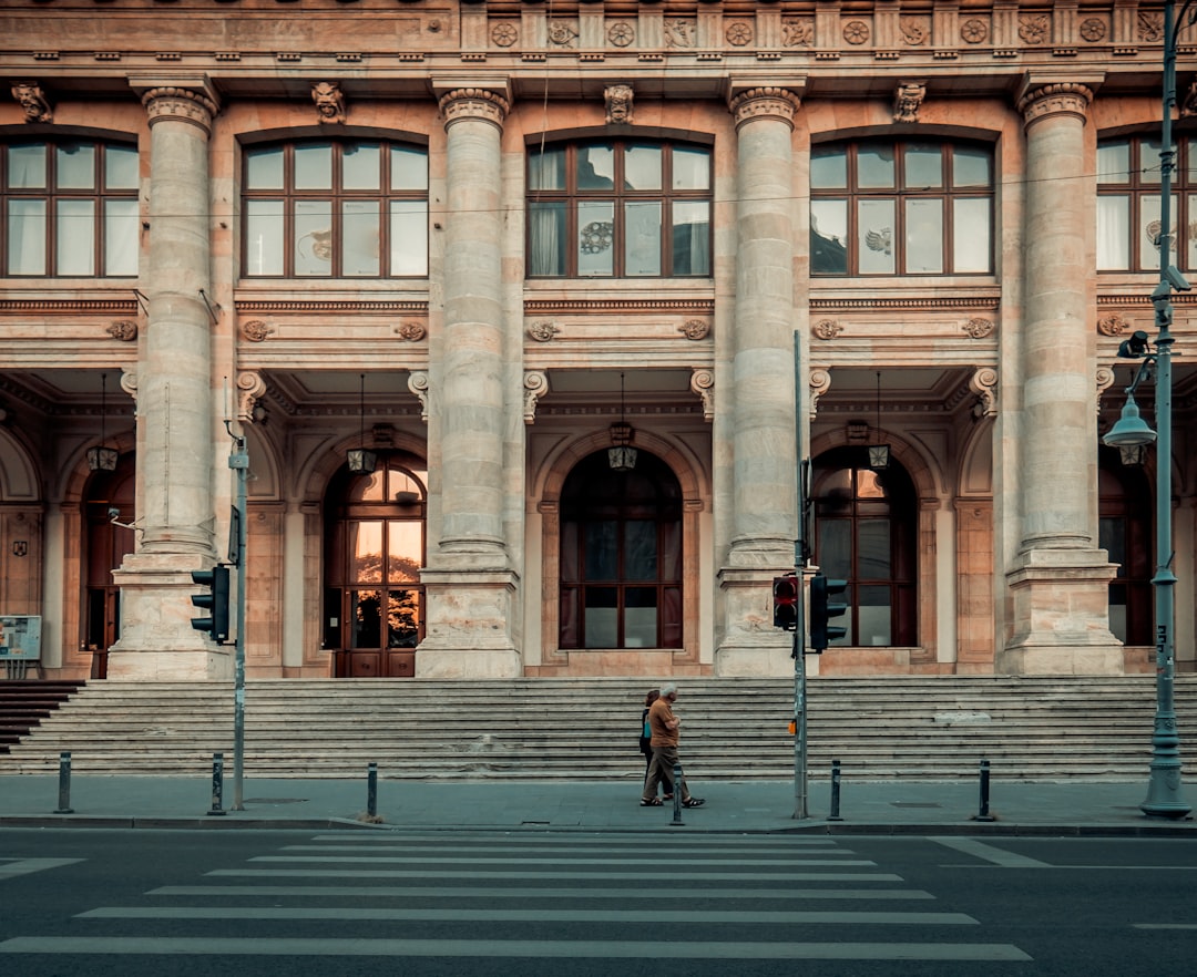 person walking pass building, Europe.