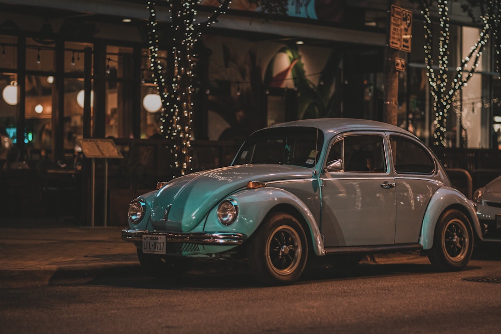 classic silver Volkswagen Beetle coupe parked beside curb