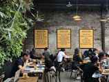 Entrepreneurs collaborating over coffee, laptops open, vibrant energy in a cozy nook of The Junction.