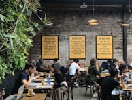 Customers laughing and chatting over coffee at a communal table, capturing the friendly atmosphere.