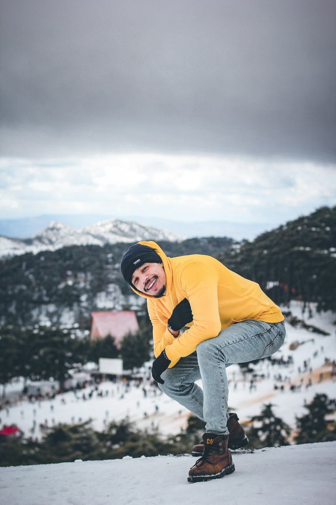 man wearing yellow and black jacket bending and smiling