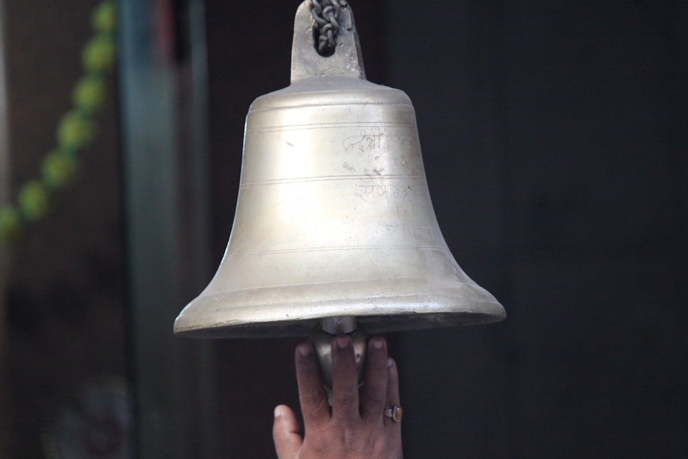 person holding hanging bell