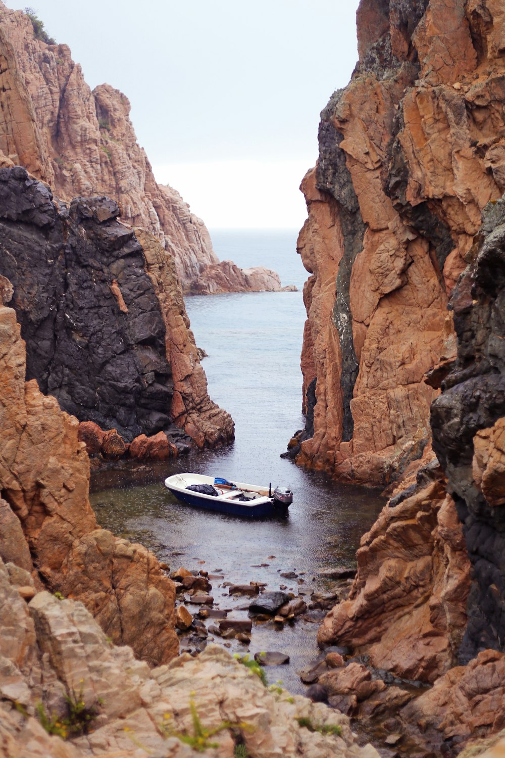 white boat near rock formation