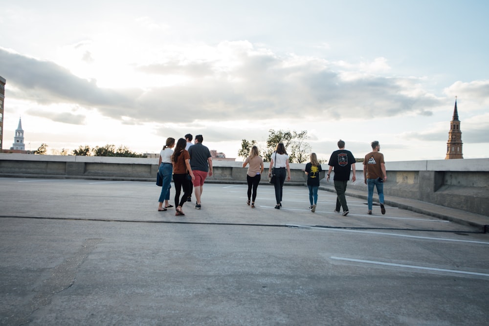 a group of people walking across a parking lot