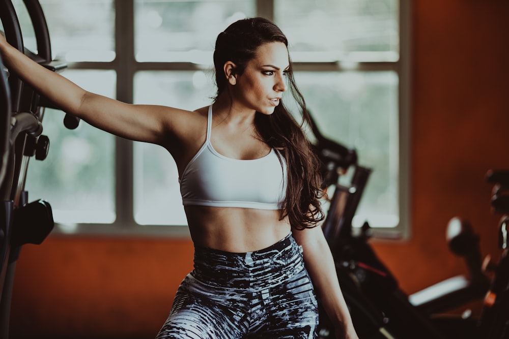 Eine Frau in einem Sport-BH-Top und Leggings in einem Fitnessstudio