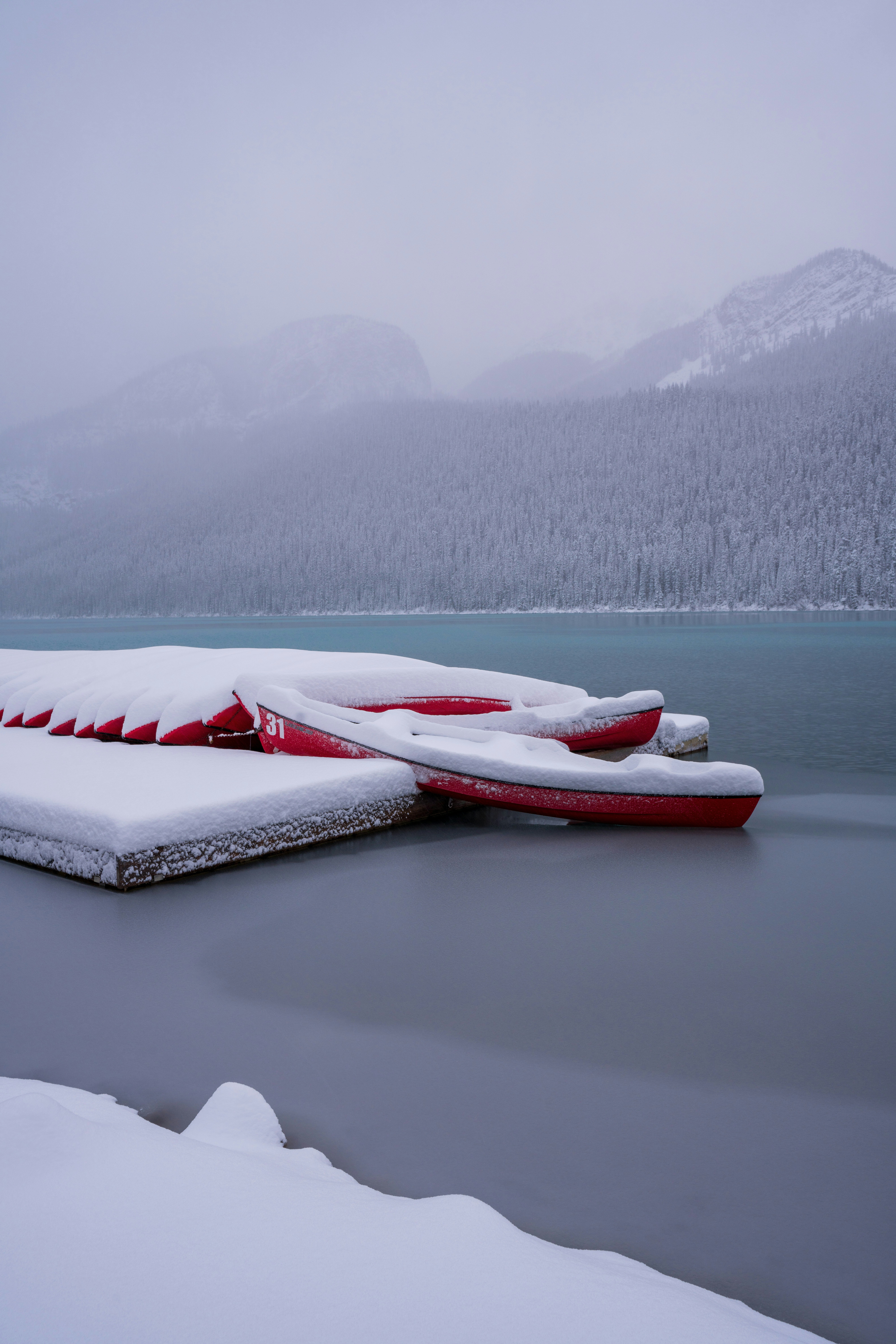 white and red boats on body of water viewing mountain during daytime